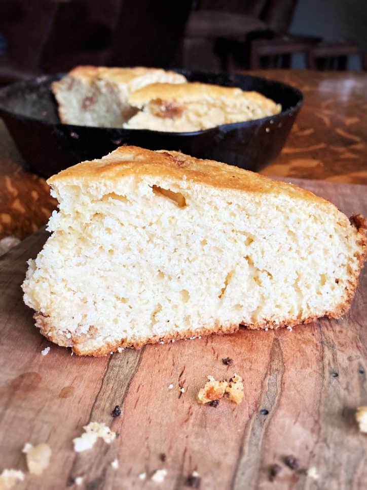 side view of a slice of cracklin cornbread on cutting board