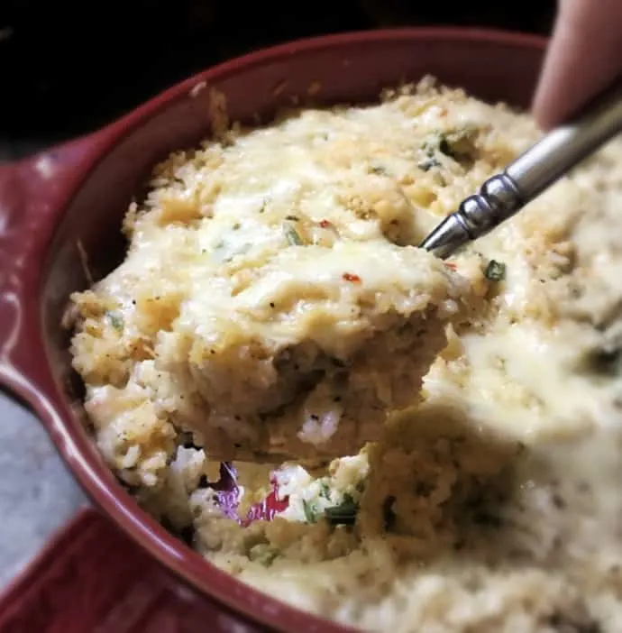 spoonful of green chili rice in red dish