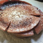 two slices of fried bologna on a paper towel