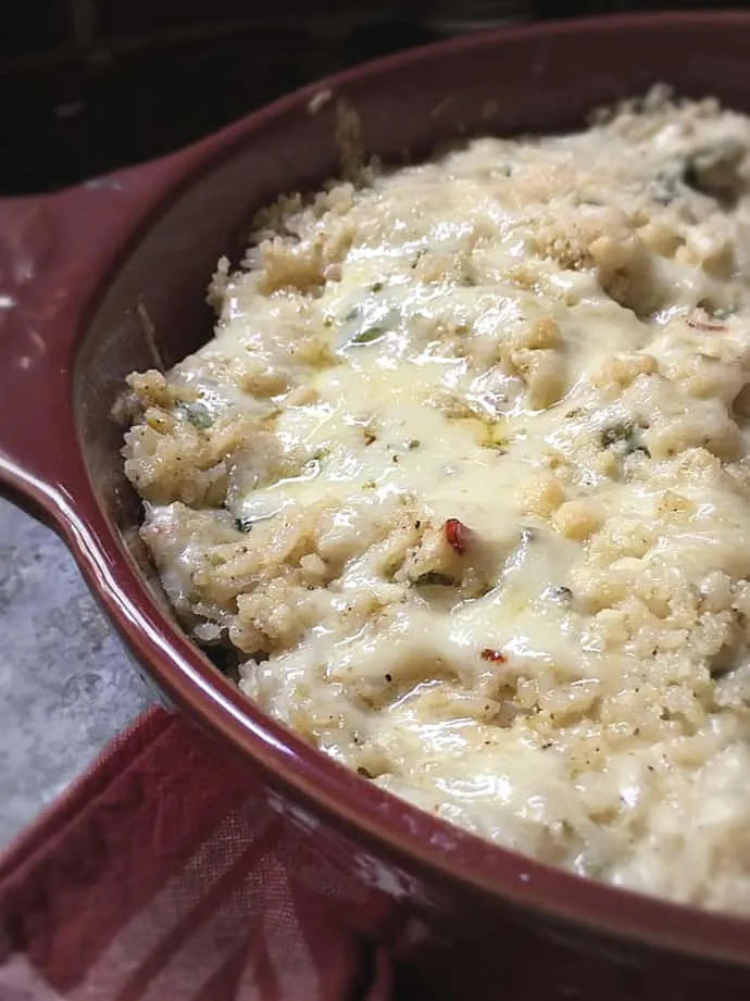 shiny cheese topped rice in round red dish