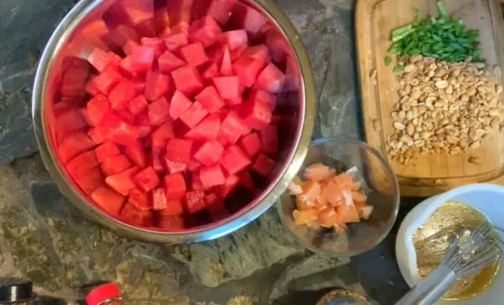 large metal bowl of watermelon and glass bowl of grapefruit