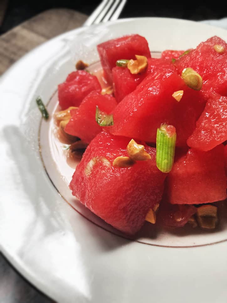 close up of watermelon grapefruit salad on a white plate