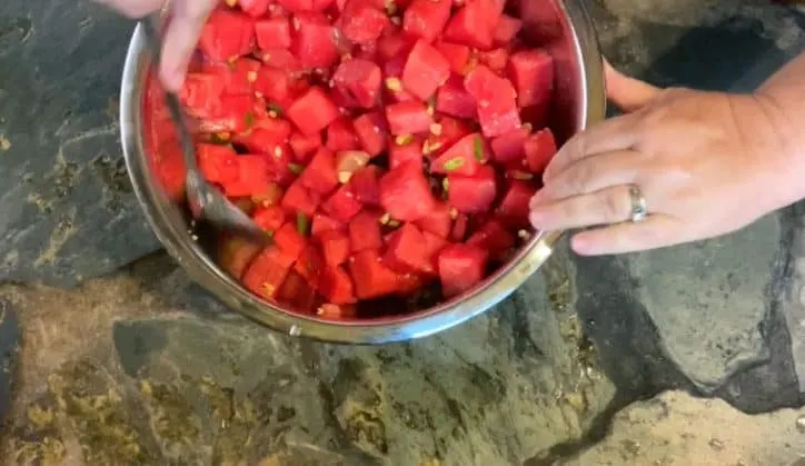 large spoon mixing the fruit salad