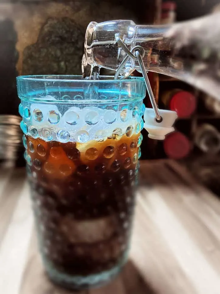 bottle pouring liquid into cup