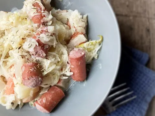 half bowl of sauerkraut and hot dogs