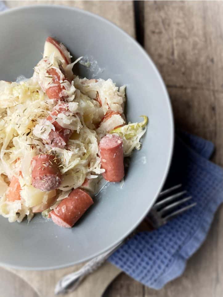 half bowl of sauerkraut and hot dogs