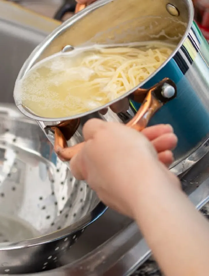 draining pasta into colander