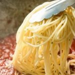 adding pasta to sauce