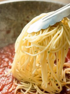 adding pasta to sauce