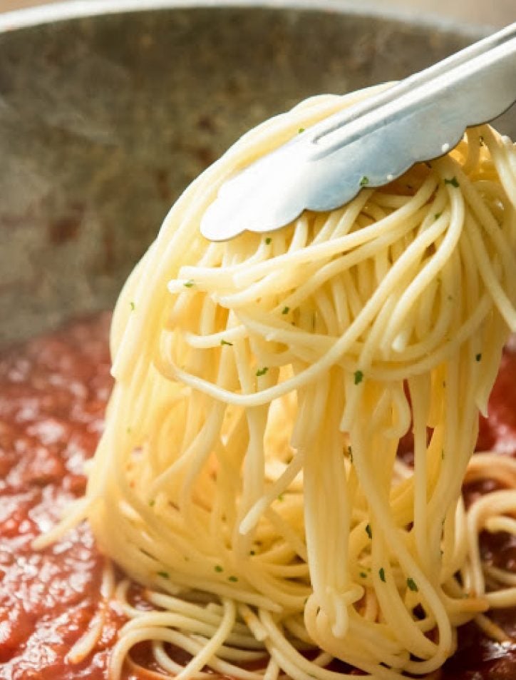 adding pasta to sauce