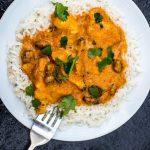Fruity Mild Chicken Curry With Boiled Rice Against a Dark Textured Background