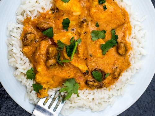 Fruity Mild Chicken Curry With Boiled Rice Against a Dark Textured Background