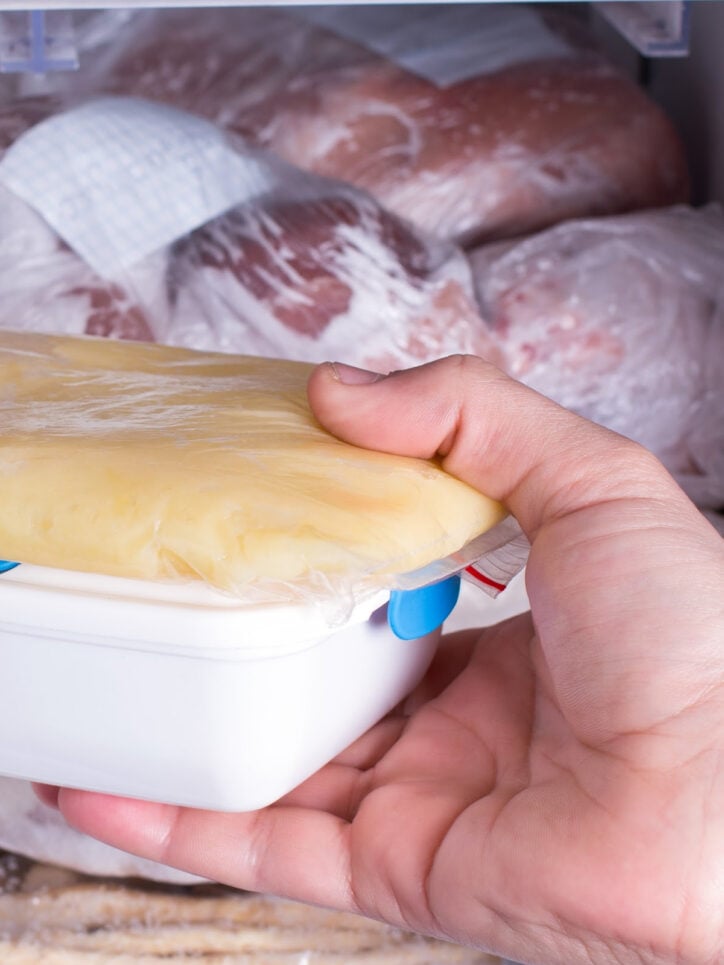 placing white container in the freezer.