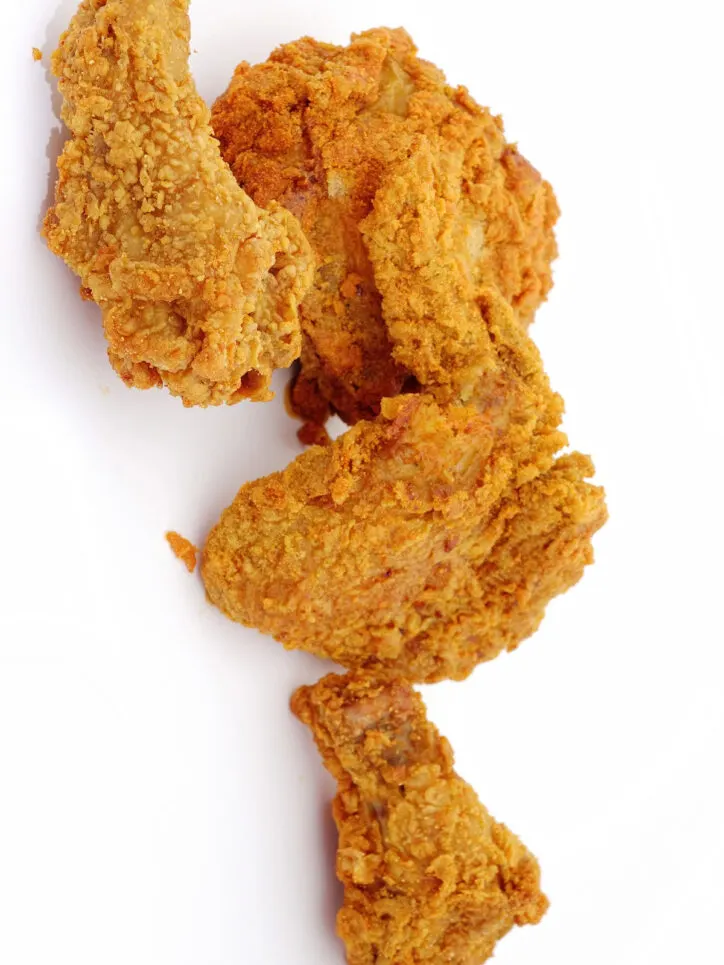 Pieces of fried chicken on white background.
