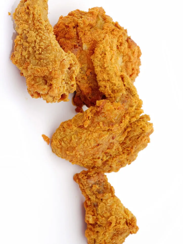 Pieces of fried chicken on white background.