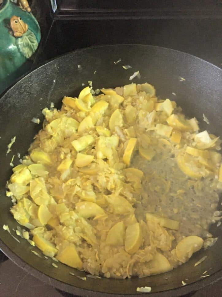 Cooking grated squash in skillet.