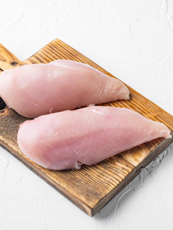 raw chicken breasts on cutting board.