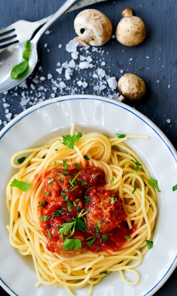 white plate of spaghetti and sauce. 