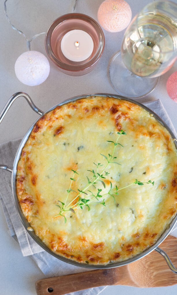 Cheesy Ham and tomato pasta with wooden spoon.