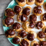 espresso custard filled cream puffs on a blue plate