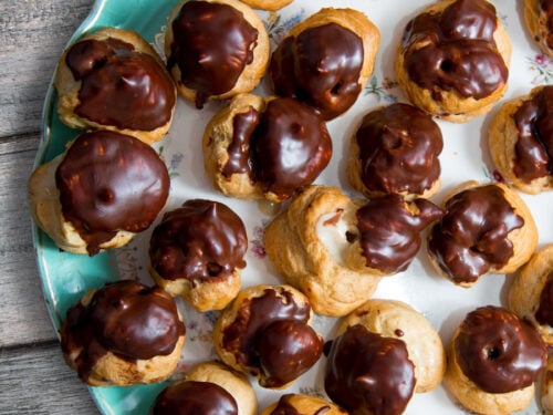 espresso custard filled cream puffs on a blue plate