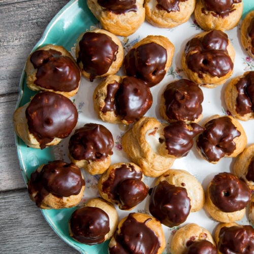 espresso custard filled cream puffs on a blue plate