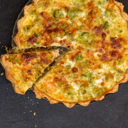 vegetable cheese quiche on black background.