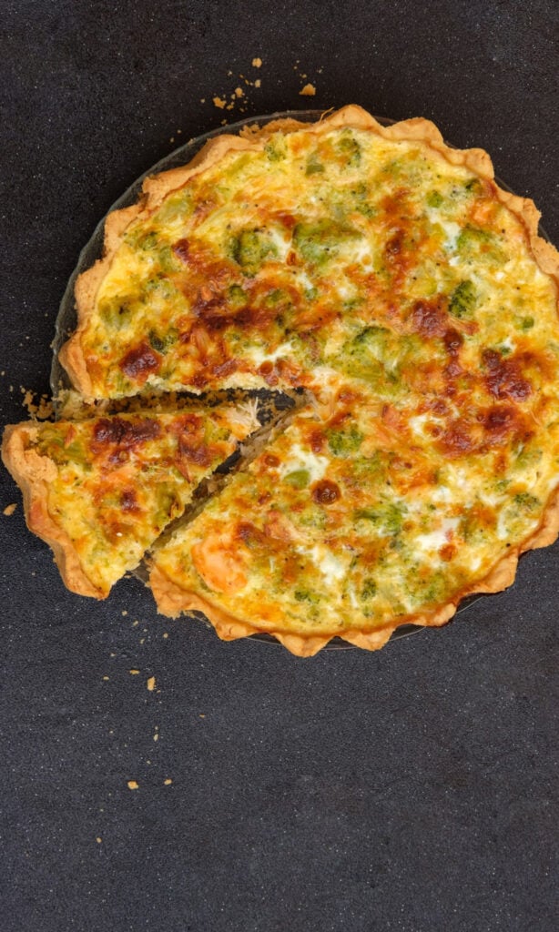 vegetable cheese quiche on black background.