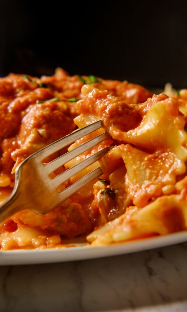 Cheesy Ham and Tomato Pasta on black background.