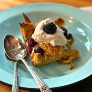slice of overnight french toast with two spoons on a blue plate
