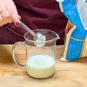 measuring powdered sugar into a glass