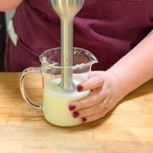 blending milk mixture with an immersion blender