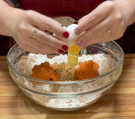 Pumpkin puree, brown sugar, and egg being added to the dry ingredients for homemade Starbucks copycat pumpkin scones.