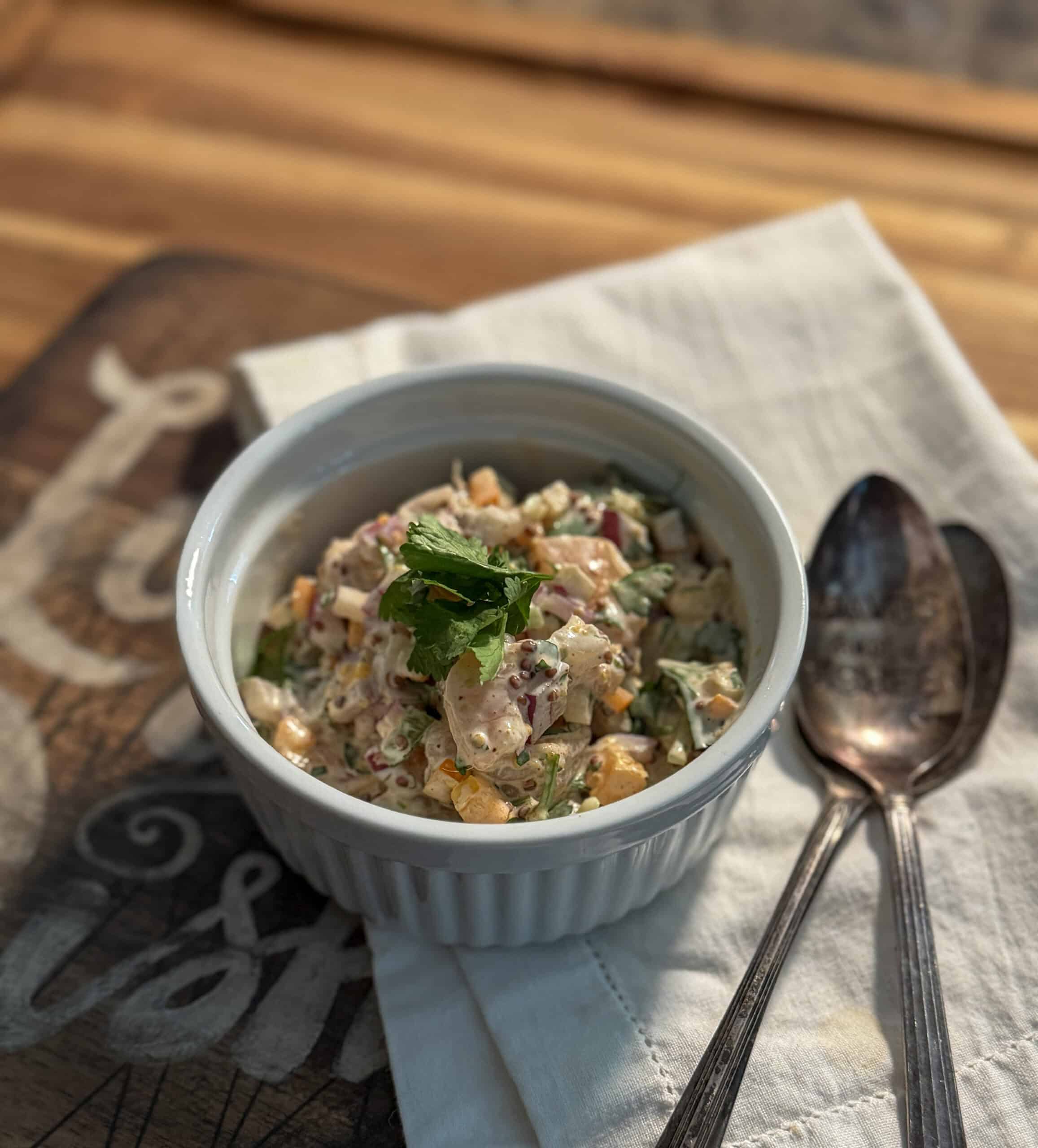 creamy shrimp salad in a white bowl topped with parsley