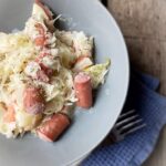 half bowl of sauerkraut and hot dogs